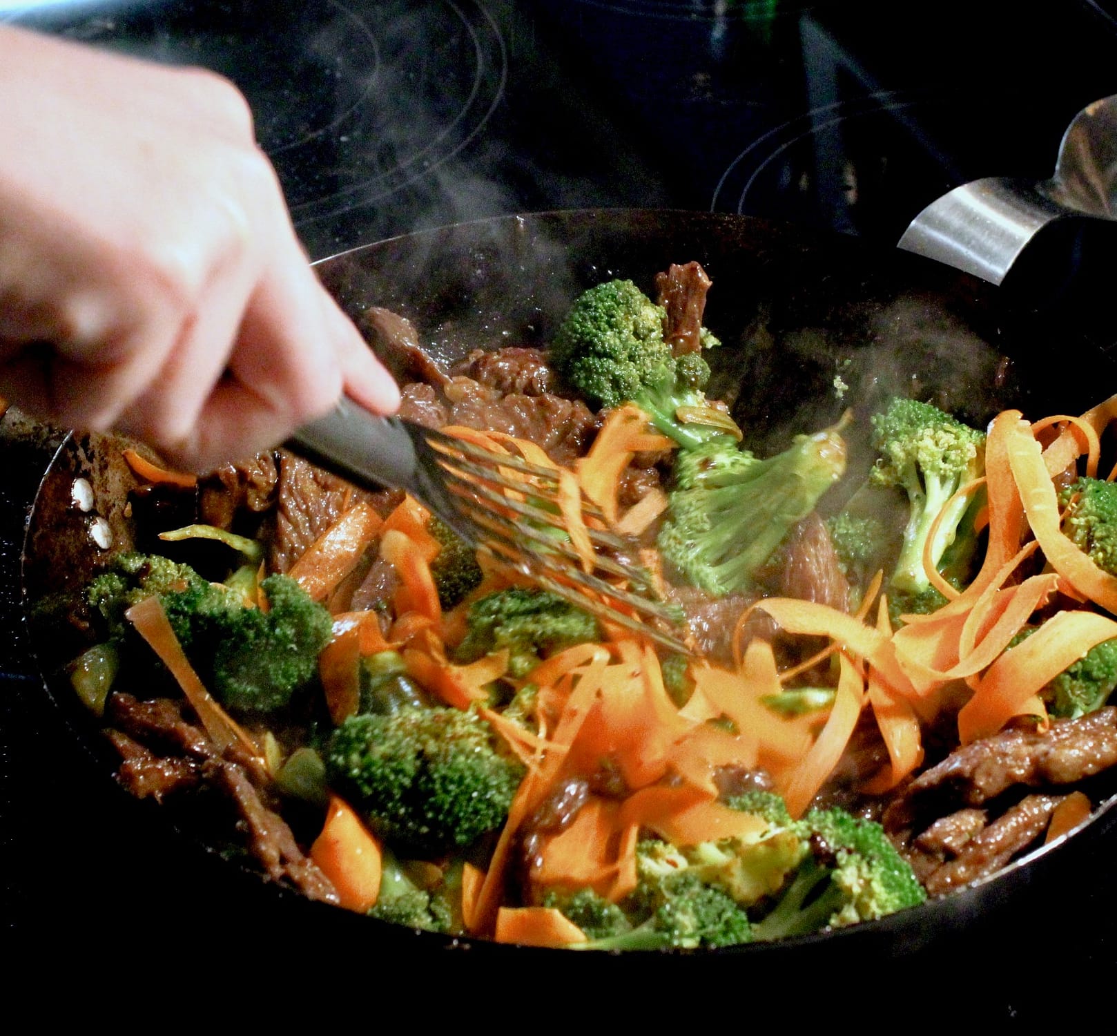 Adding the remaining vegetables to the beef with broccoli.