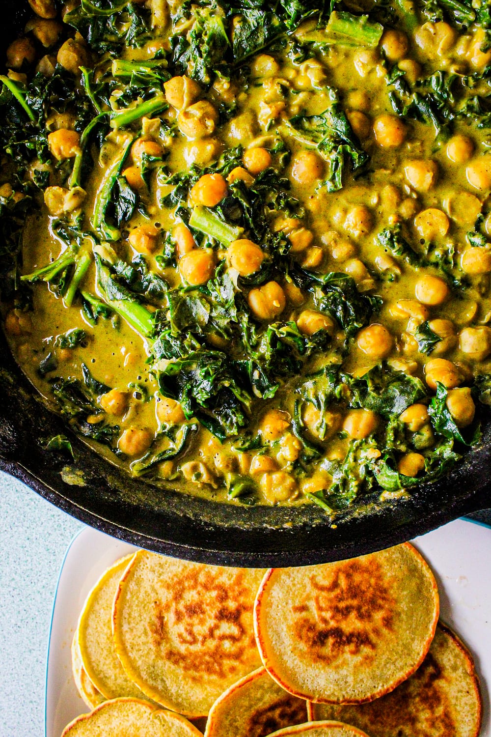 Cast iron skillet filled with chana masala.