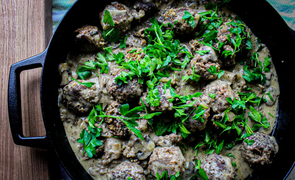 Meatballs and mushroom gravy with parsley on top.