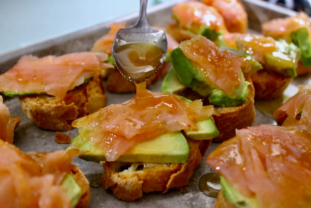 Drizzling honey over smoked salmon starters.