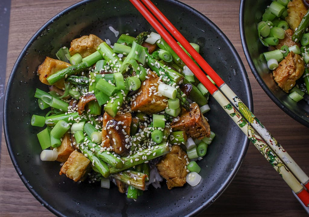 Tofu stir fry in a bowl with chopsticks