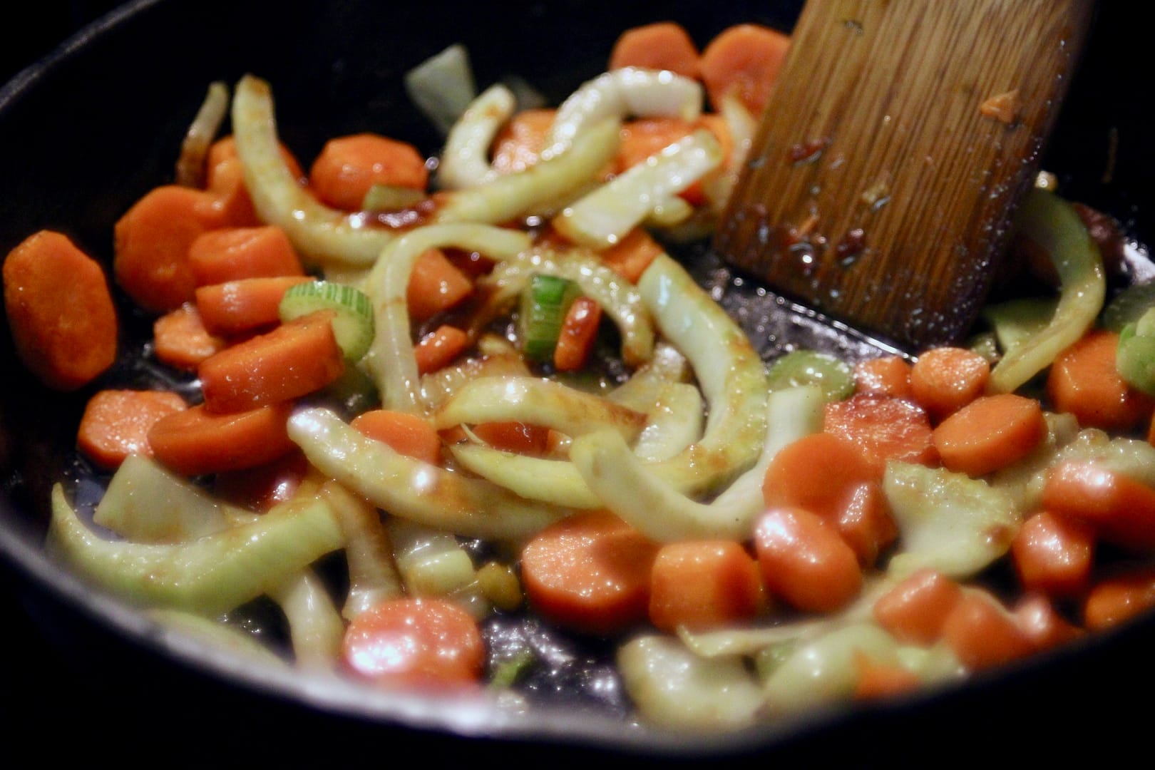 Carrots and fennel being sauteed in a cast iron skillet for the beans and kale.