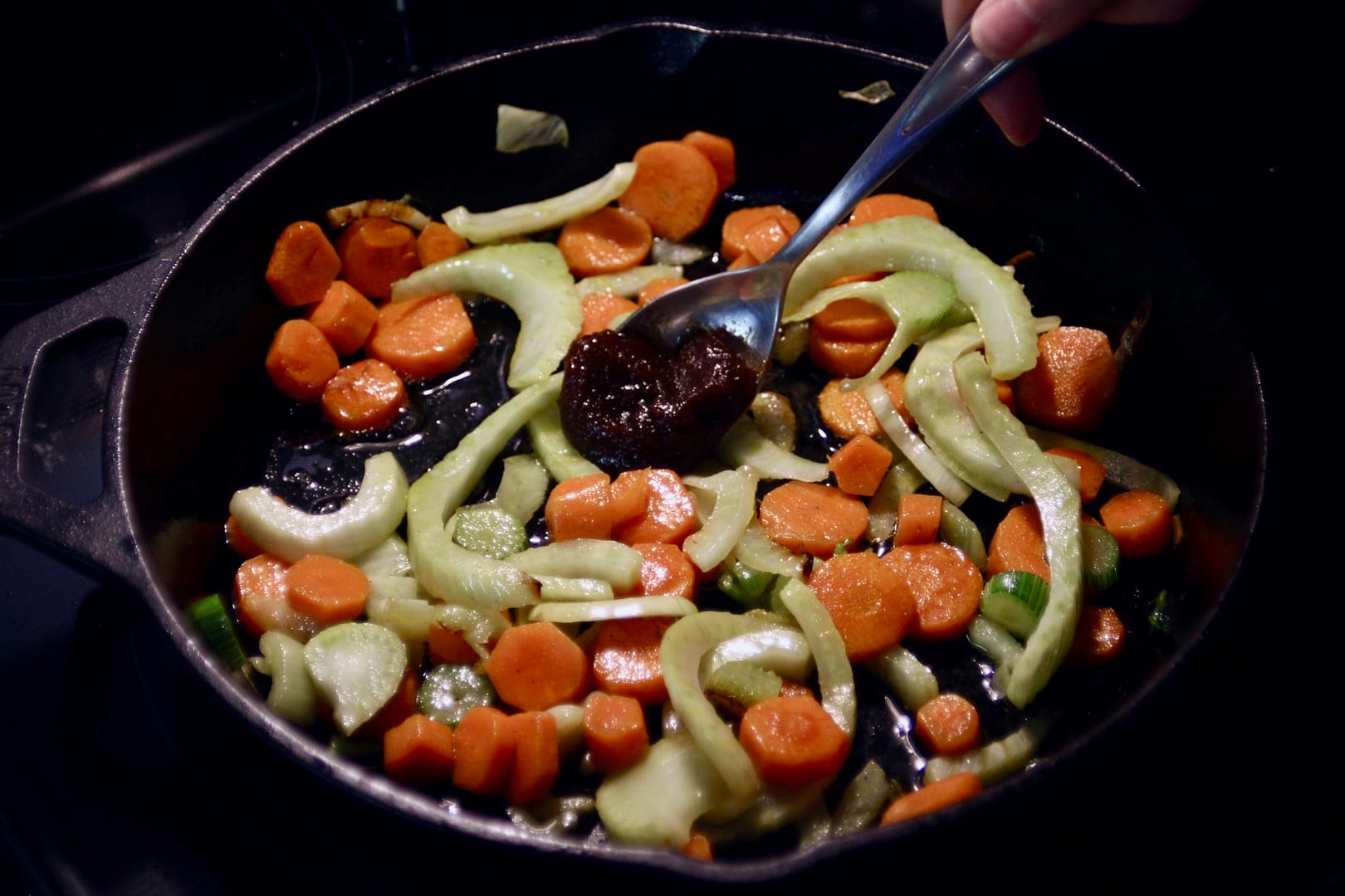 Adding bouillion to the carrots and fennel in the skillet.