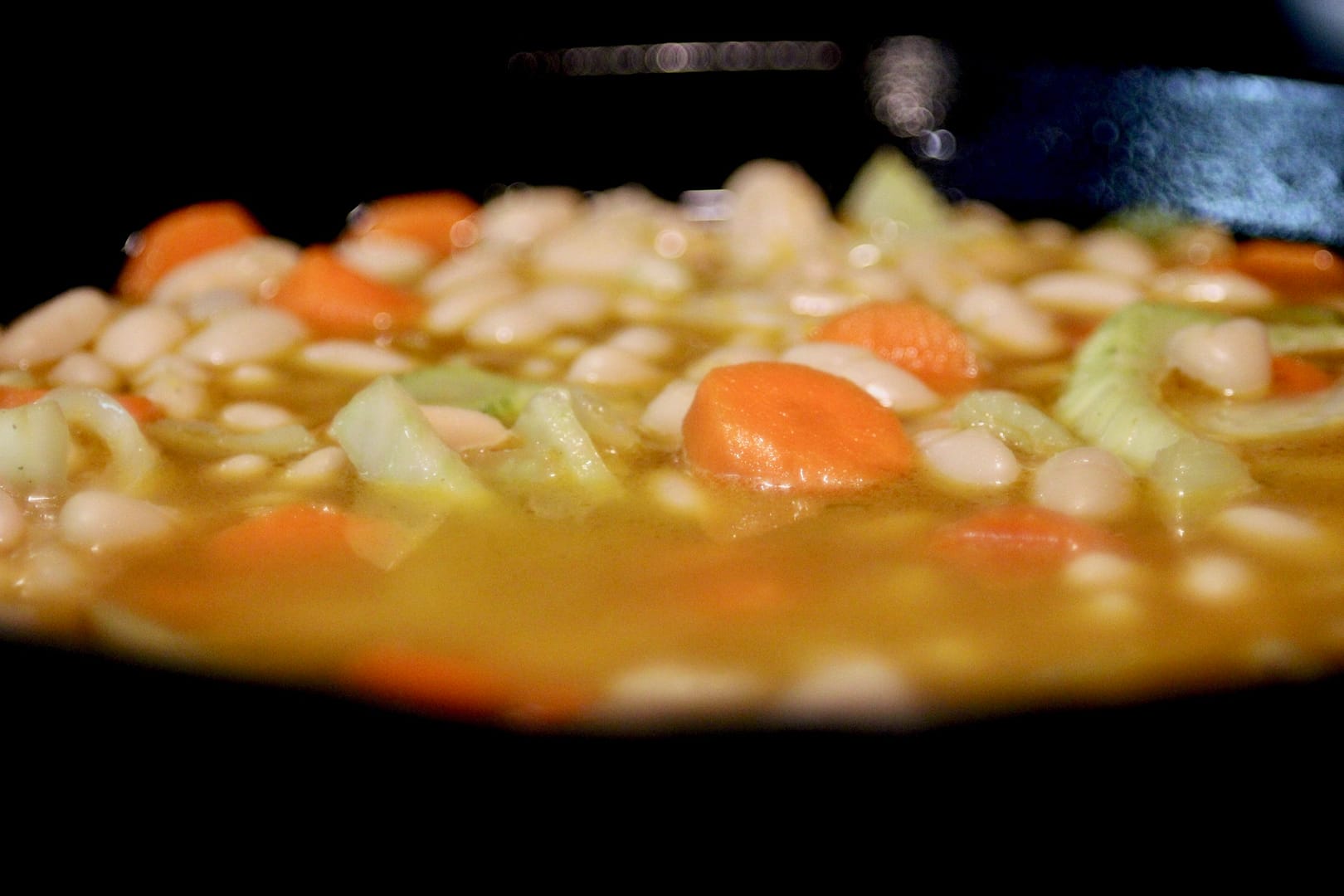 Adding the broth to the beans.