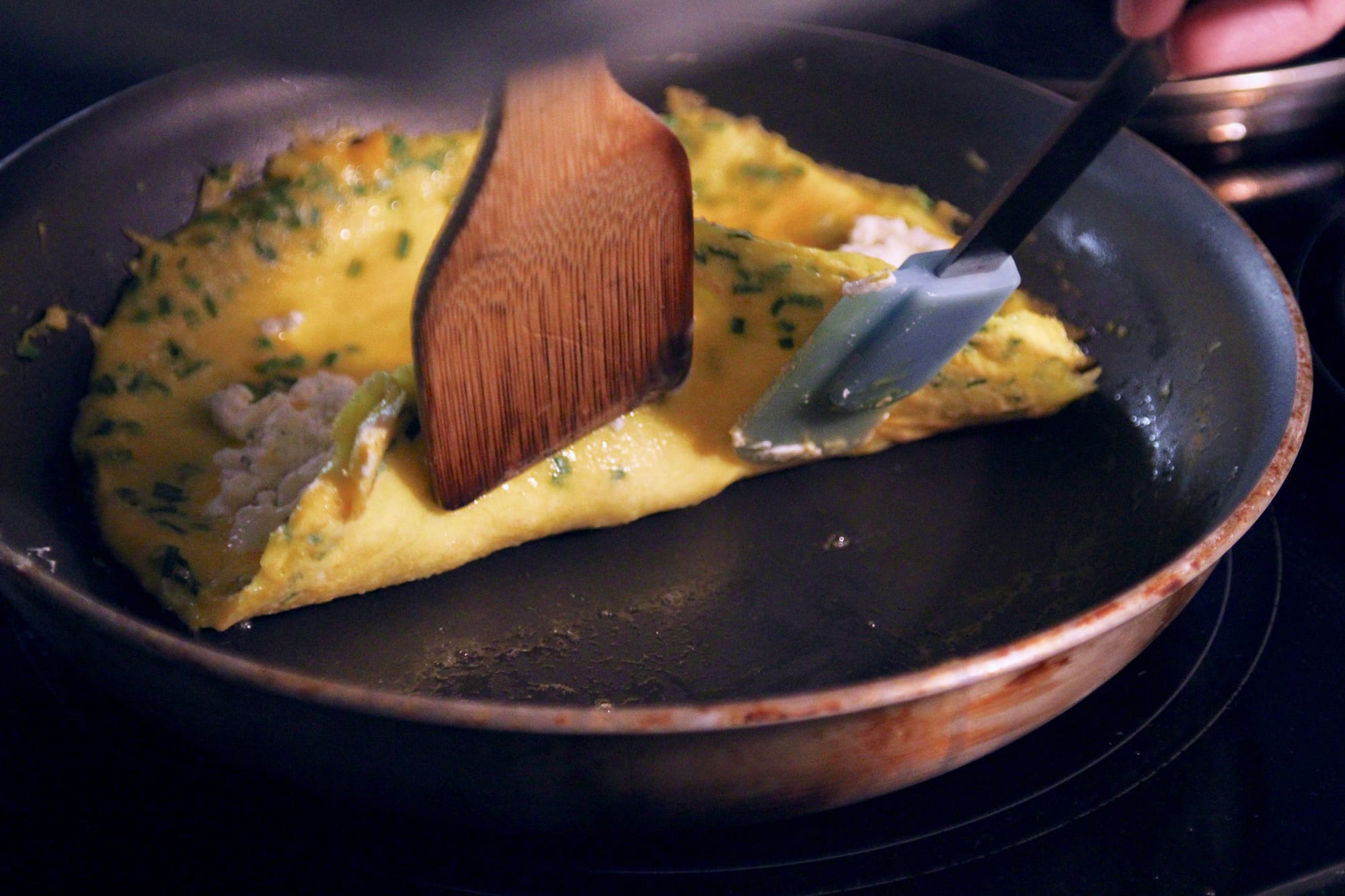 Folding one third of the french omelette.