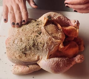 Putting herb rub on chicken