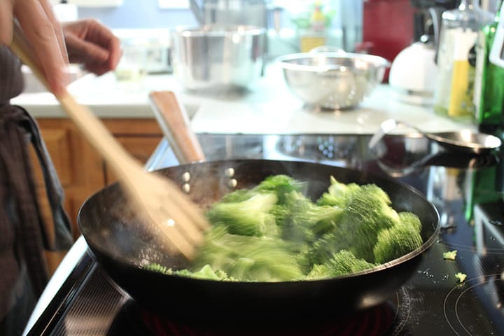Sauteeing broccoli in a wok.